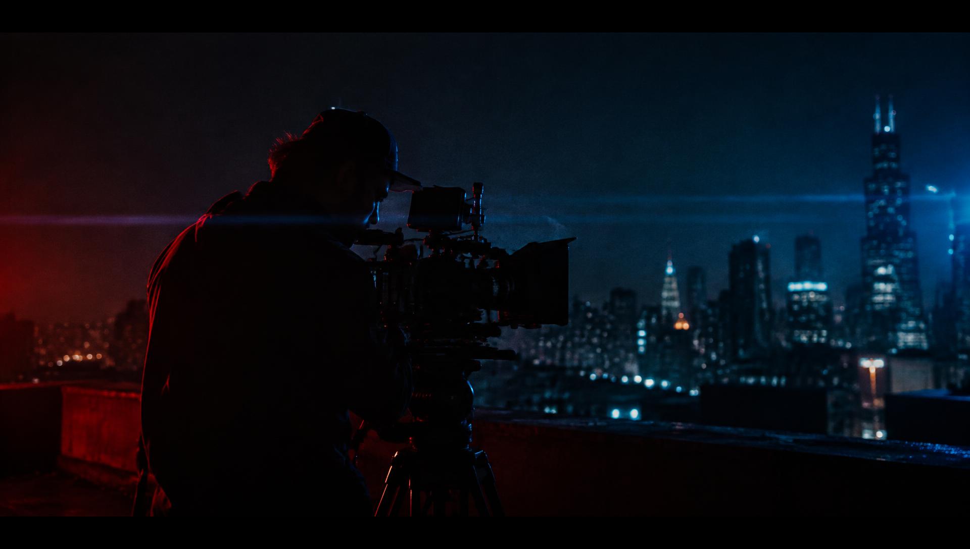 Filmmaker on a rooftop at night